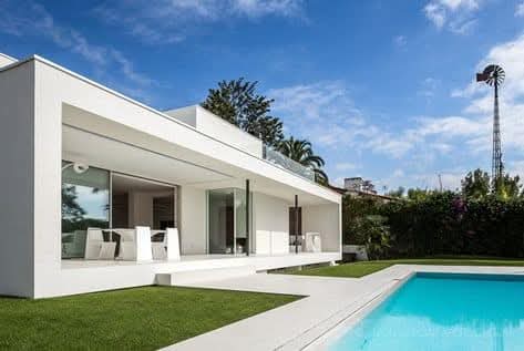 Fachada de casa minimalista blanca con piscina
